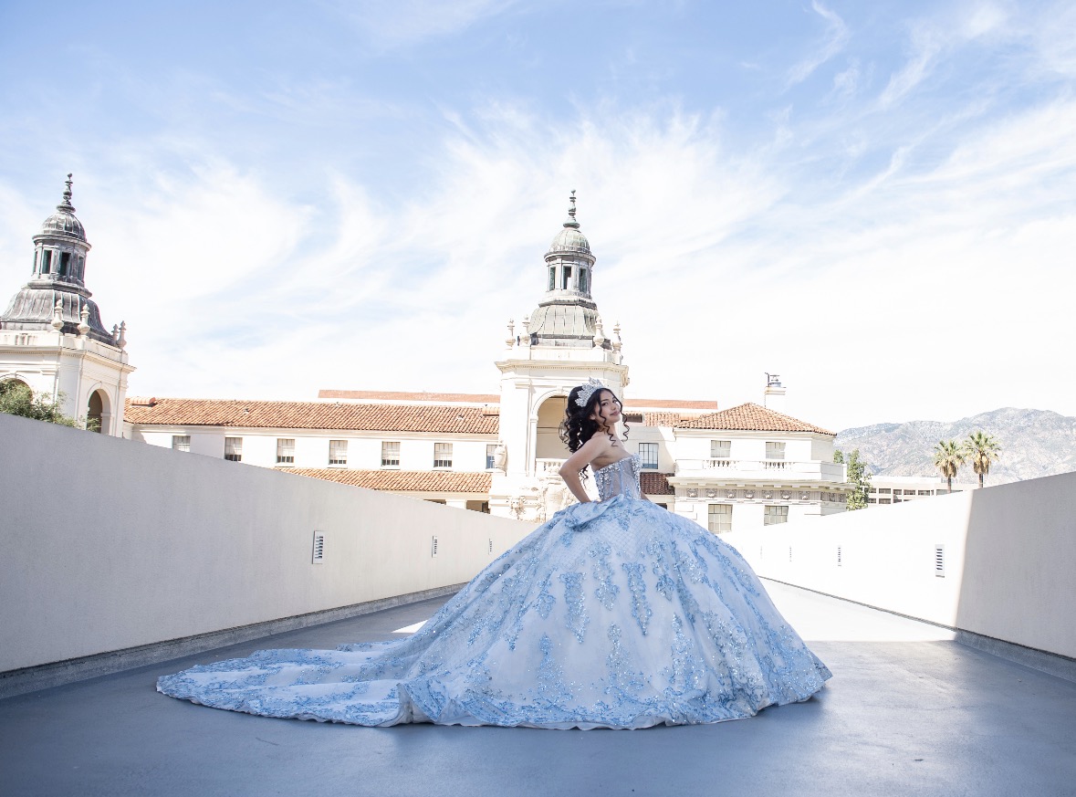 Quinceañera in a blue ball gown on a rooftop
