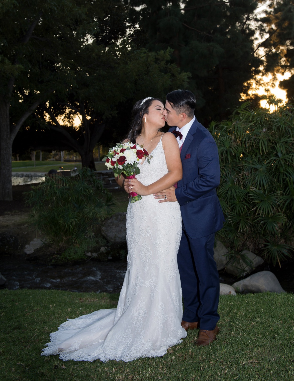 Couple kissing at sunset during a reception