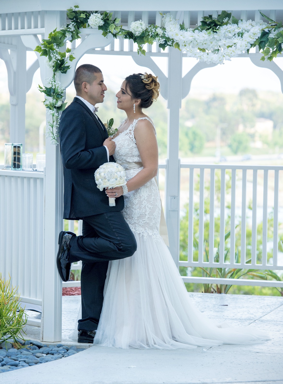 Bride and groom under a floral gazebo
